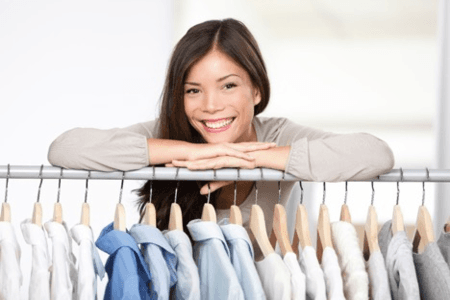 woman smiling over shirt rack