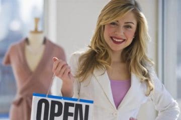 fashion retailer holding an open sign