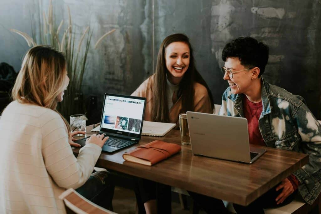 Happy women collaborating in a modern workspace, sharing ideas and enjoying a productive meeting.